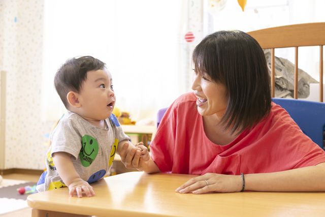 向き合う保育士とエンゼル保育園園児
